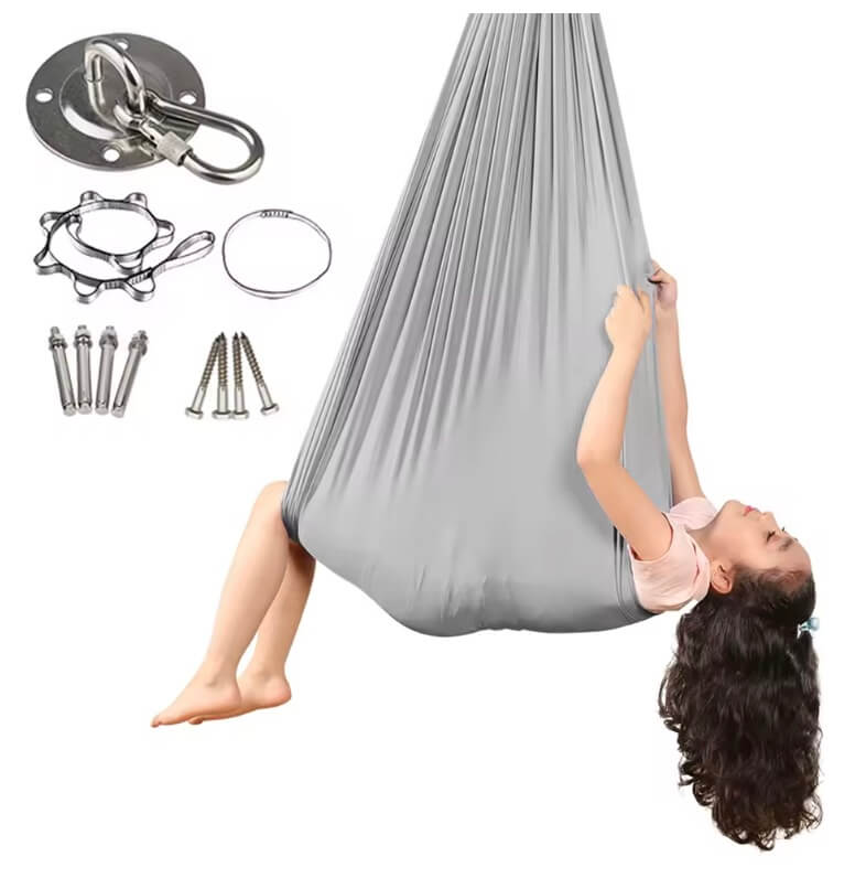 Kind liegt in einer grauen Therapieschaukel, daneben sind Befestigungszubehör wie Deckenhalterung, Karabiner und Schrauben abgebildet.