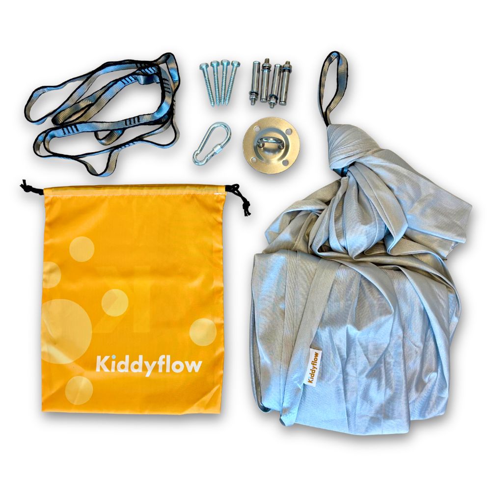 Graue Kiddyflow Therapieschaukel mit komplettem Lieferumfang: Befestigungsset, Karabiner, Verlängerungsgurt und gelbem Kiddyflow-Aufbewahrungsbeutel.