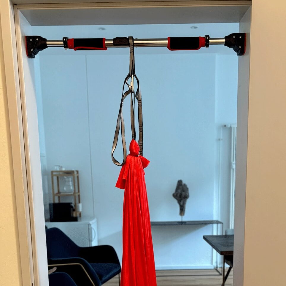 Rote Therapieschaukel von Kiddyflow an einer Türaufhängung im Türrahmen befestigt.