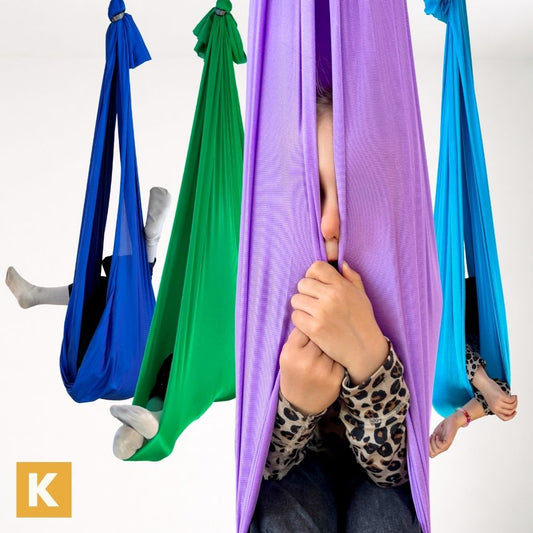 Kinder in bunten Therapieschaukeln