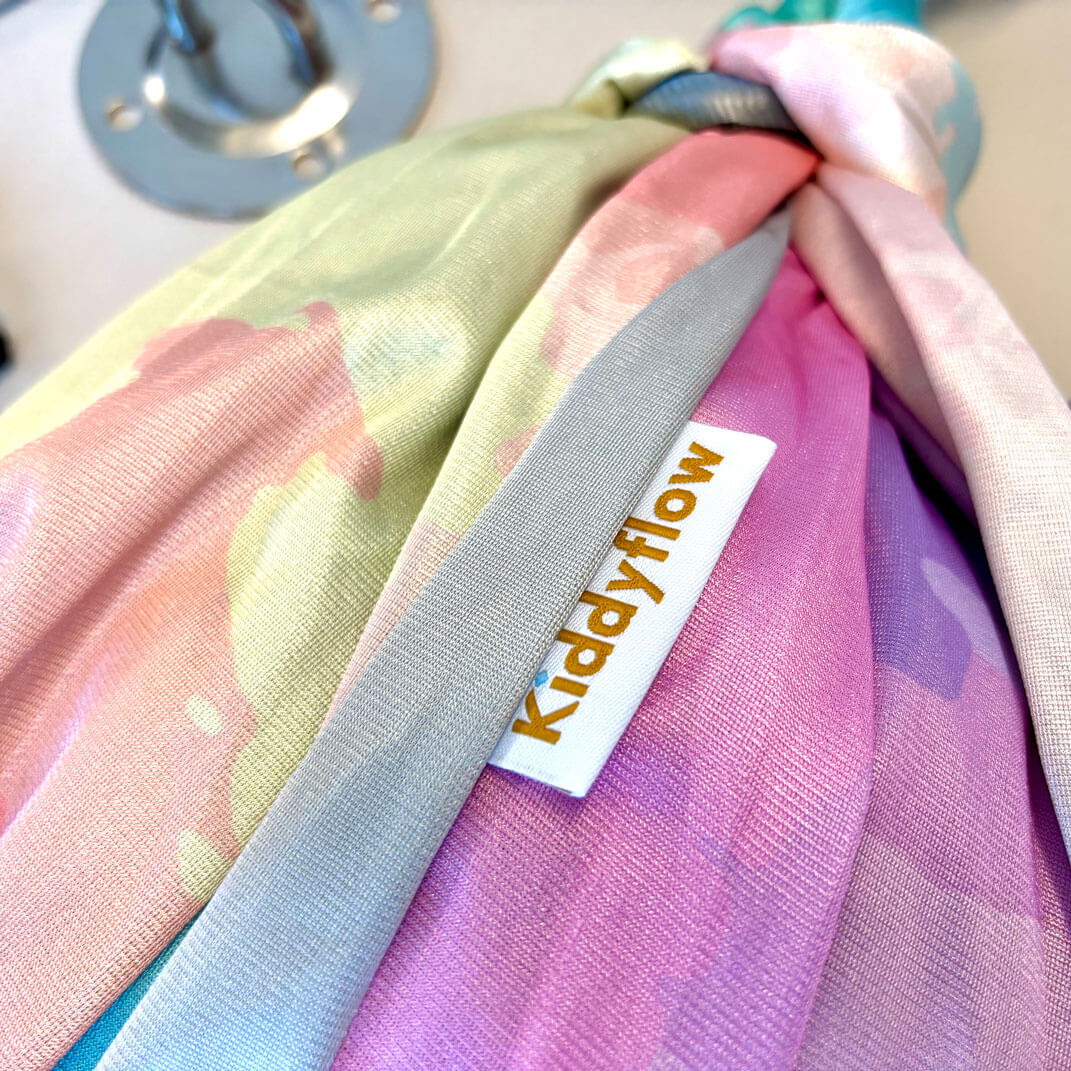 Detailaufnahme der doppellagigen Kiddyflow Flow Therapieschaukel 2.0 im Rainbow-Design mit sichtbarem Kiddyflow-Label und Stoffstruktur.