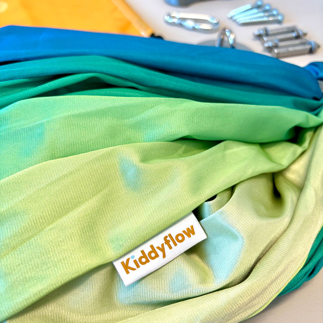 Detailaufnahme der doppellagigen Kiddyflow Flow Therapieschaukel 2.0 im Youth-Bean-Green-Design mit sichtbarem Kiddyflow-Label und Stoffstruktur.