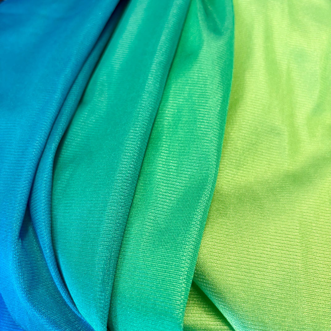 Nahaufnahme des Stoffes der Kiddyflow Therapieschaukel 2.0 im Youth-Green-Verlauf – Detail der weichen, elastischen Textilstruktur.