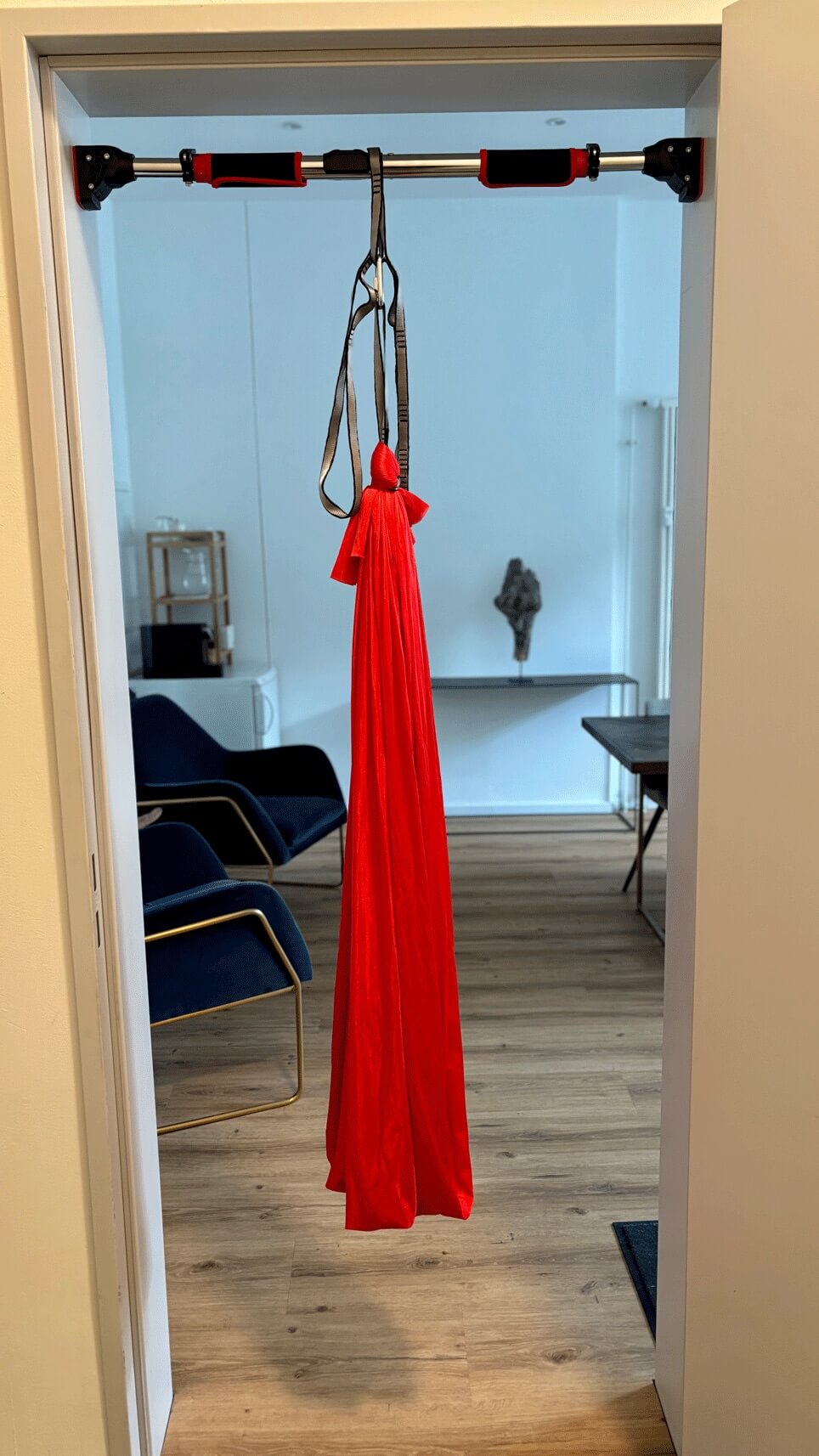 Rote Therapieschaukel von Kiddyflow an einer Türaufhängung im Türrahmen befestigt.