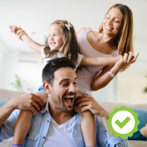 Lachende Familie in einer positiven Stimmung, daneben ein grünes Häkchen als Symbol für Zufriedenheitsgarantie.
