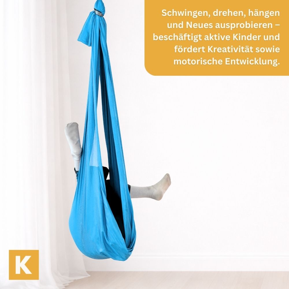 Kind turnt in einem hellblauen Schaukeltuch von Kiddyflow im Innenbereich