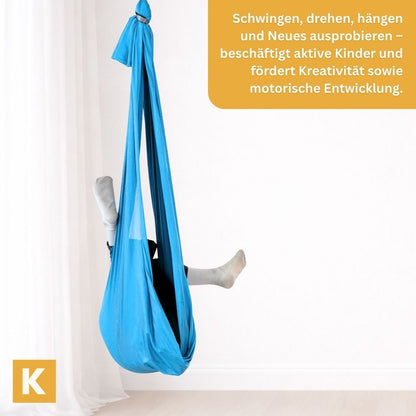 Kind turnt in einem hellblauen Schaukeltuch von Kiddyflow im Innenbereich