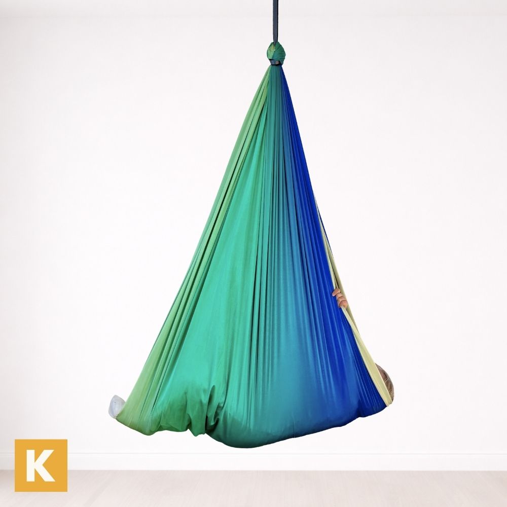 Kind geborgen in einem Schaukeltuch 2.0 Rainbow Grey von Kiddyflow im Innenbereich