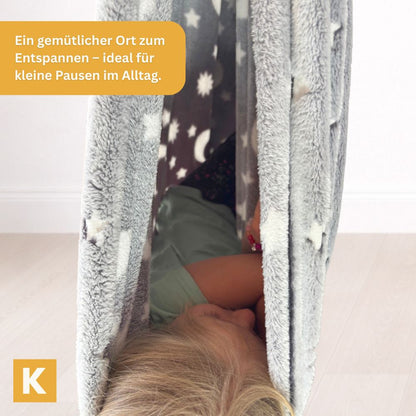 Kind geborgen in der Glow Schaukel Grey Star von Kiddyflow im Innenbereich