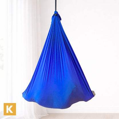 Kind in einer blauen Therapieschaukel von Kiddyflow im Innenbereich