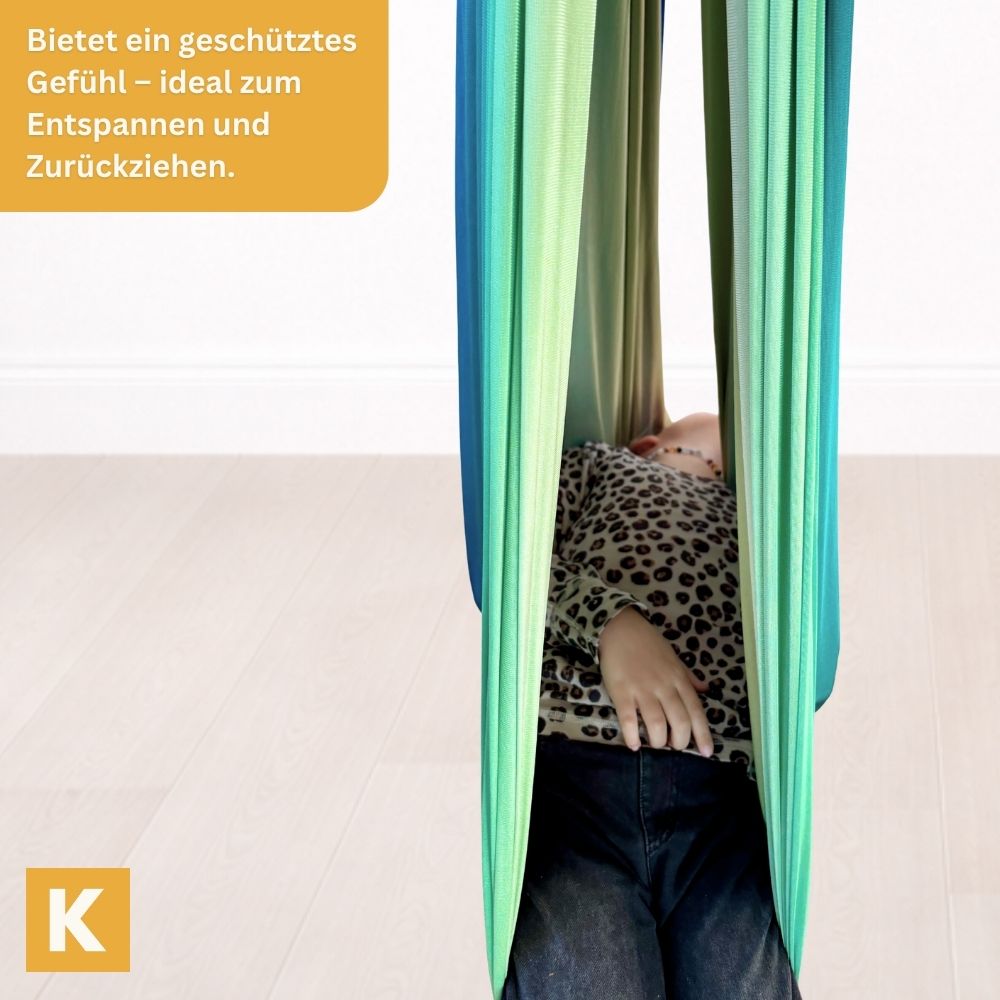 Kind entspannt in der Therapieschaukel 2.0 Rainbow Grey von Kiddyflow