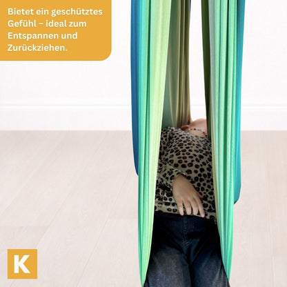 Kind entspannt in der Therapieschaukel 2.0 Rainbow Grey von Kiddyflow
