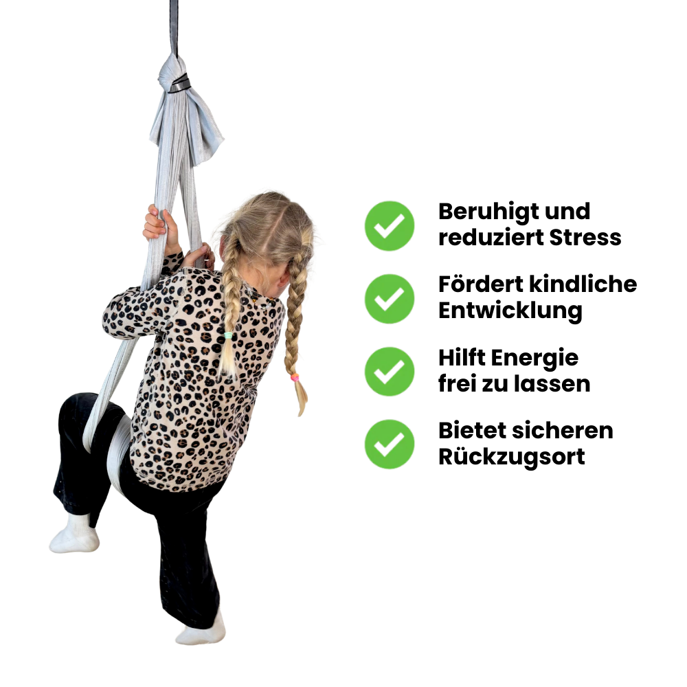 Kind in grauer Therapieschaukel mit Vorteilen wie Stressabbau, Förderung der Entwicklung und sicherem Rückzugsort